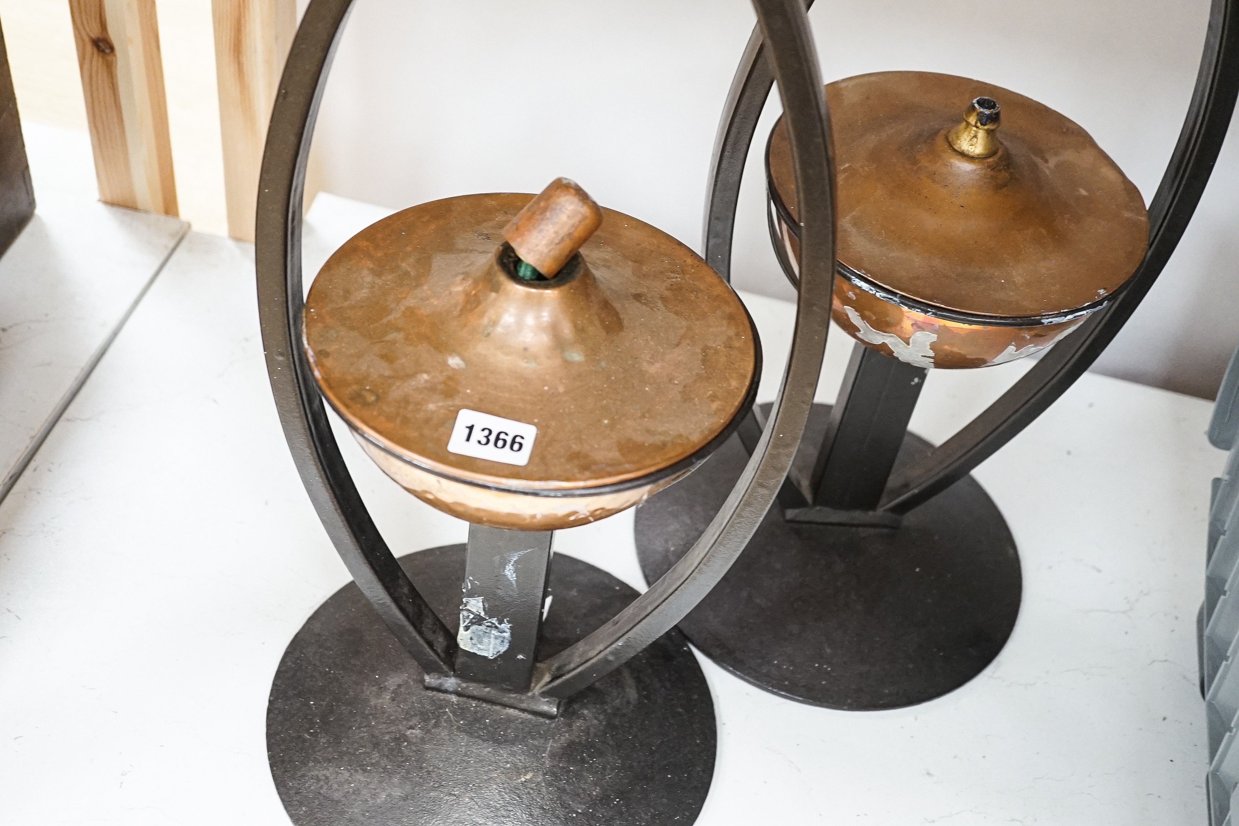 A pair of decorative copper lamps in arched mounts, 61 cms high.